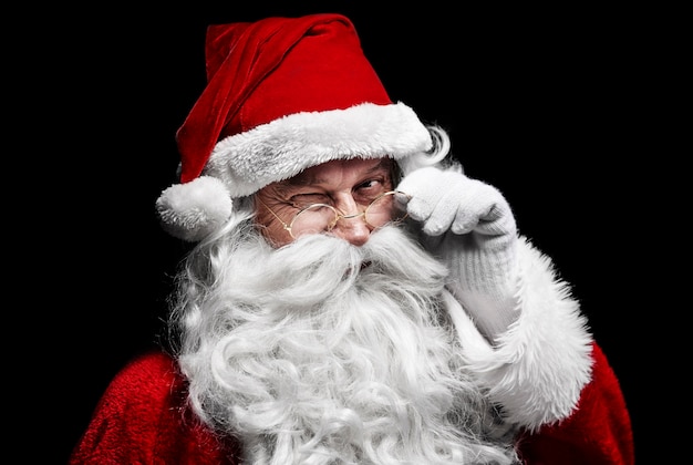 Homem fantasiado de Papai Noel piscando o olho