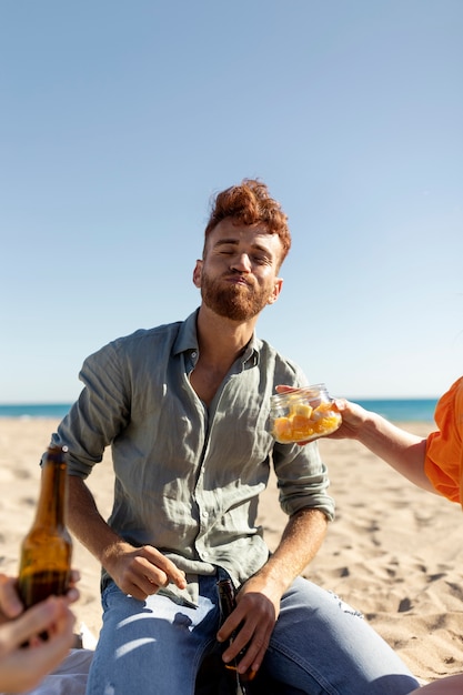 Homem se divertindo com amigos à beira-mar