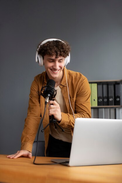 Homem sorridente gravando podcast de tiro médio