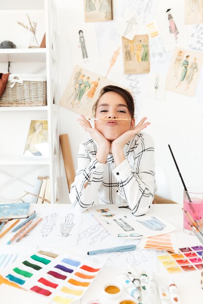 Ilustrador de moda senhora engraçada sentado à mesa e brincando