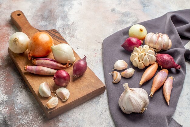 Foto grátis ingredientes frescos de cebolas e alhos de vista frontal