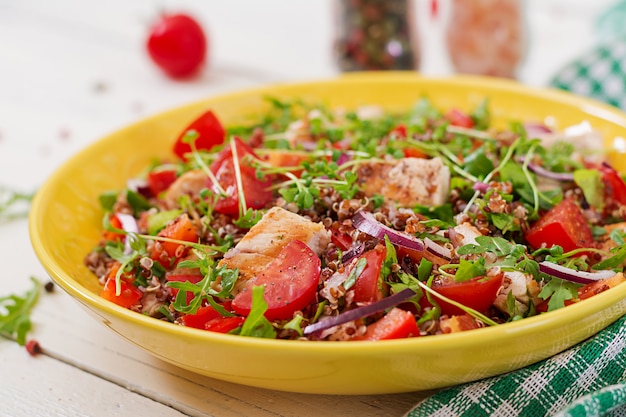 Jantar saudável. Almoço na tigela de salada com frango e quinoa grelhado, tomate, pimentão, cebola roxa e rúcula