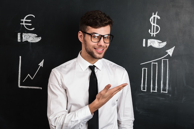 Foto grátis jovem bem sucedido na camisa branca, apresentando novo projeto financeiro