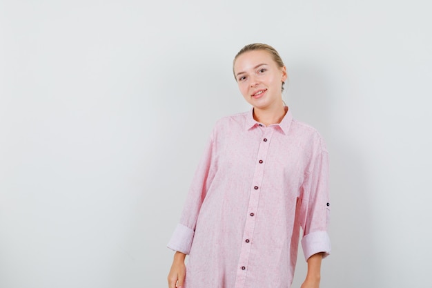 Foto grátis jovem mulher com uma camisa rosa e parecendo alegre