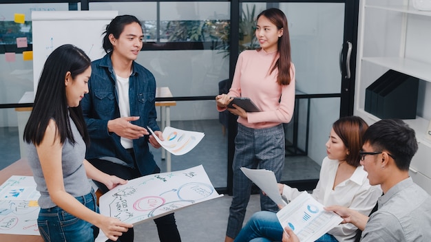 Foto grátis jovens empresários e empresárias asiáticos felizes reunindo ideias para um brainstorming