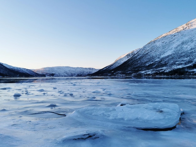 Foto grátis lago congelado nas colinas cobertas de neve em kattfjorden, noruega, capturado durante o dia