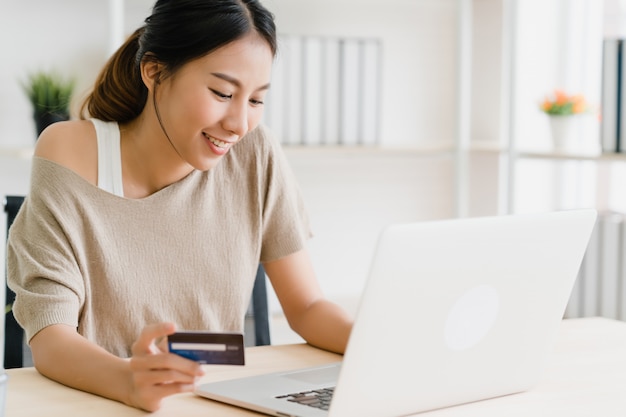 Foto grátis linda mulher asiática usando computador ou laptop comprando compras on-line por cartão de crédito