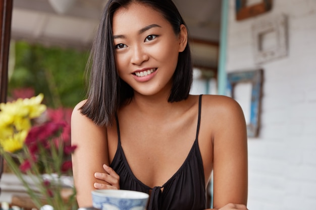 Foto grátis lindo retrato de uma mulher chinesa com penteado cortado, poses em quarto aconchegante