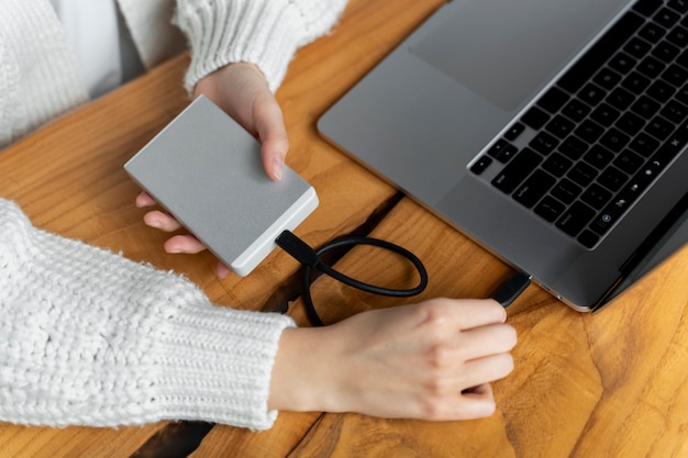 Foto grátis mãos conectando ssd ao laptop de alto ângulo