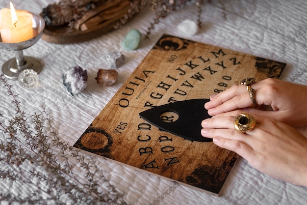 Foto grátis mãos usando o tabuleiro ouija de madeira