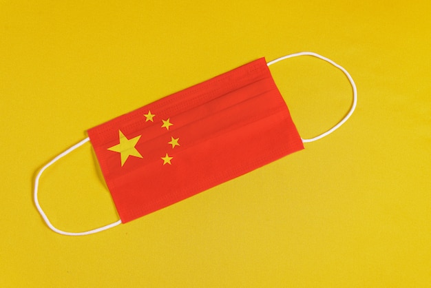 Foto grátis máscara cirúrgica em fundo amarelo com bandeira da china