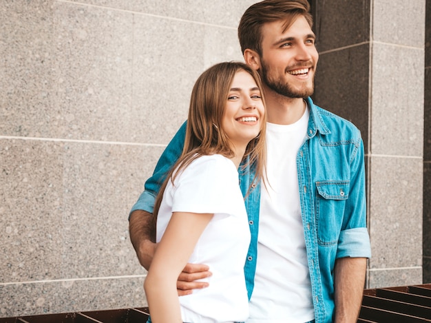 Foto grátis menina bonita sorridente e seu namorado bonito em roupas de verão casual. família feliz, tendo selfie auto-retrato de si na câmera do smartphone. se divertindo no fundo da rua