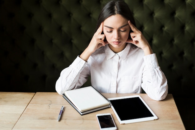 Foto grátis menina contemplativa com gadgets e bloco de notas