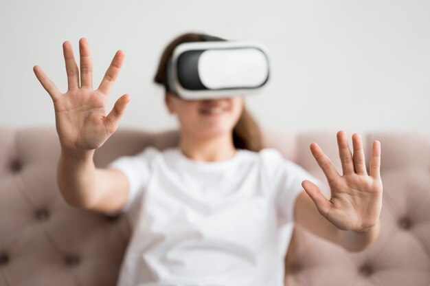 Menina de alto ângulo com fone de ouvido de realidade virtual