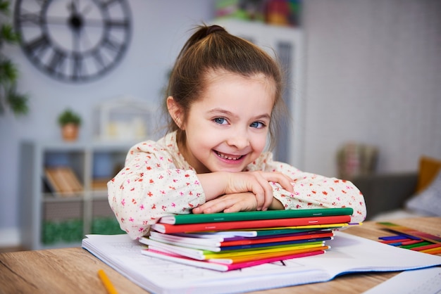 Menina sorridente estudando em casa