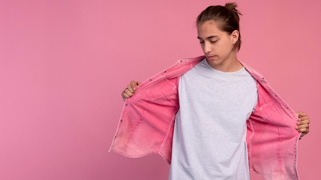 Foto grátis menino adolescente elegante em rosa posando com espaço de cópia