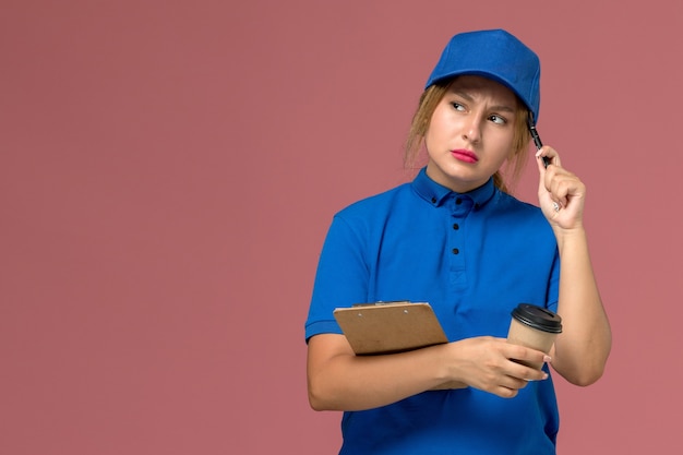 mensageira feminina em uniforme azul posando segurando uma xícara de café e o bloco de notas com a expressão do pensamento em rosa, entrega de uniforme de serviço