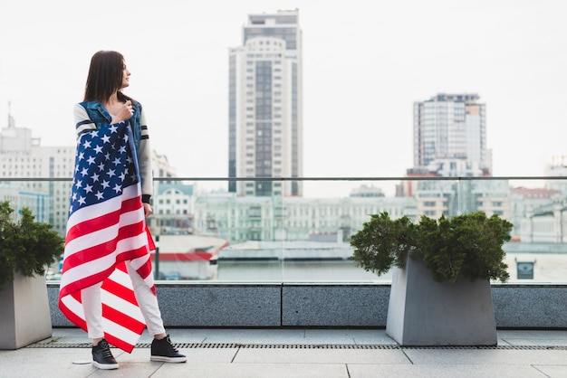 Foto grátis mulher alta na varanda envolto na bandeira americana