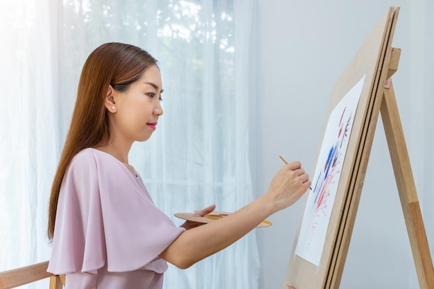 Foto grátis mulher artista feminina pintando imagens em casa como seu hobby