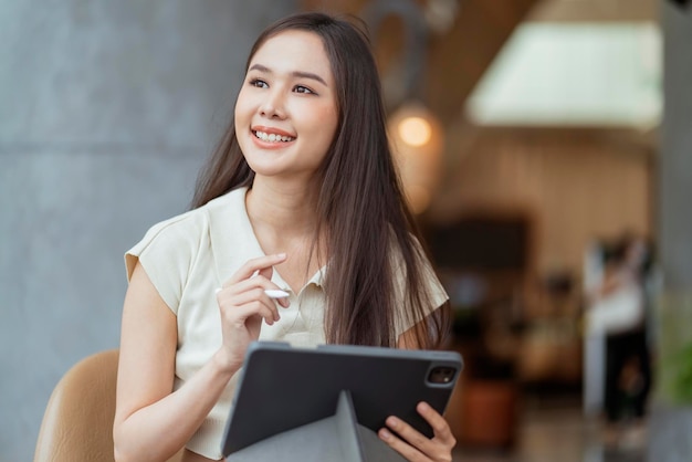 Foto grátis mulher asiática freelance nômade digital carreira felicidade trabalho alegre sorrindo trabalhando online com dispositivo inteligente tablet smartphone no exterior projeto de ocupação trabalho em qualquer lugar novo estilo de vida sem moldura