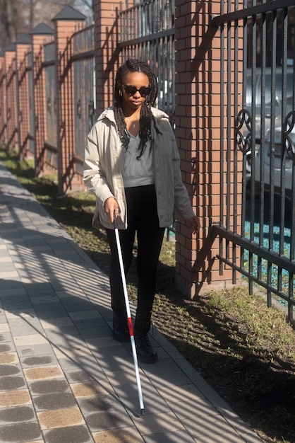 Foto grátis mulher cega de tiro completo andando com bengala branca