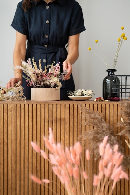 Foto grátis mulher de vista frontal trabalhando com flores secas