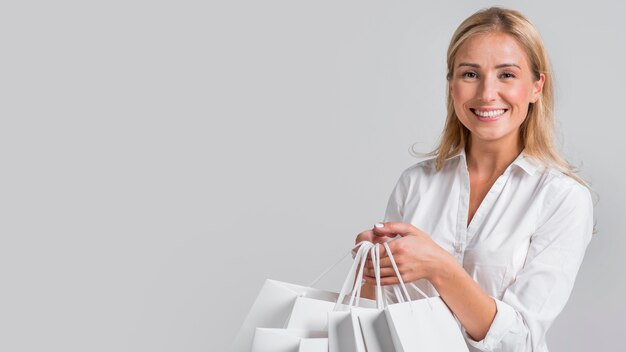 Mulher feliz segurando muitas sacolas de compras