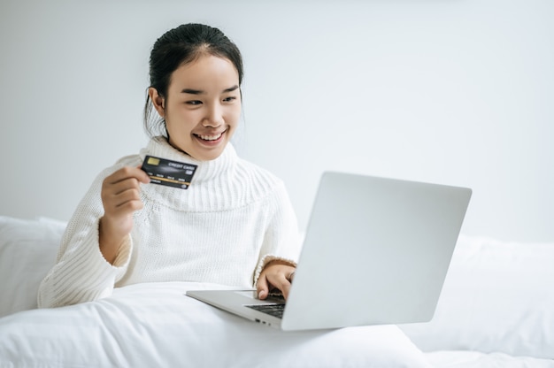 Foto grátis mulher jogando laptop e segure um cartão de crédito.