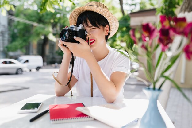 Foto grátis mulher jovem elegante com cabelo escuro curto, tornando a fotografia profissional segurando