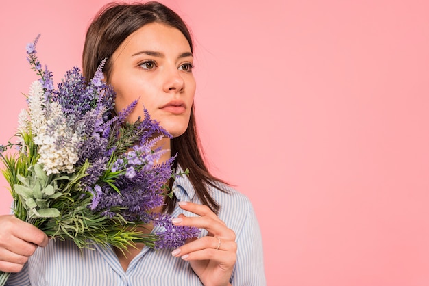 Foto grátis mulher jovem, segurando, grupo flores, perto, rosto