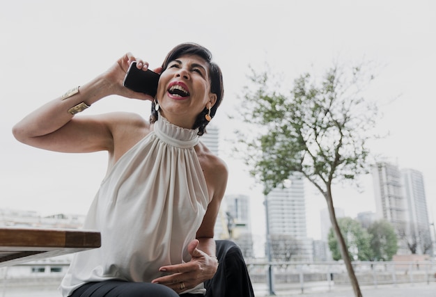 Foto grátis mulher mais velha sorridente, falando ao telefone