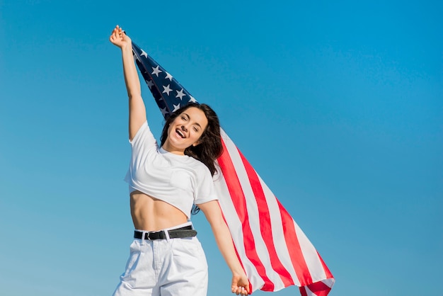 Foto grátis mulher morena com roupas brancas, segurando a bandeira dos eua grande