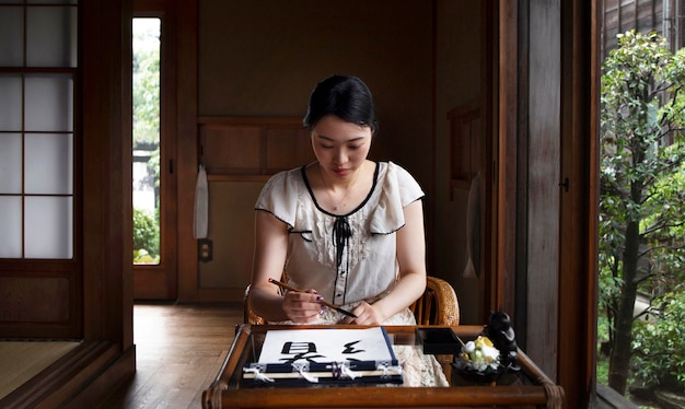 Foto grátis mulher praticando caligrafia japonesa