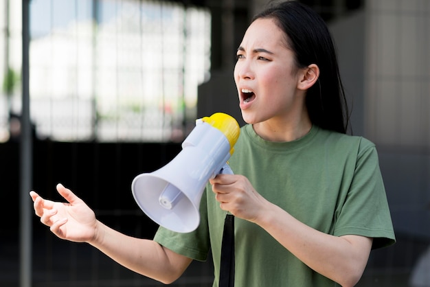 Foto grátis mulher protestando e falando no megafone