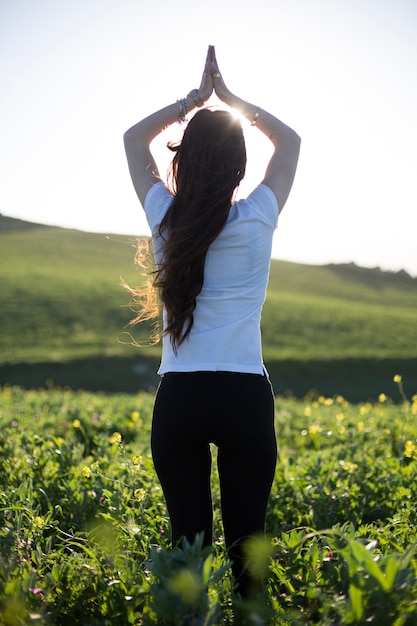 Foto grátis mulher relaxante com as mãos no campo verde