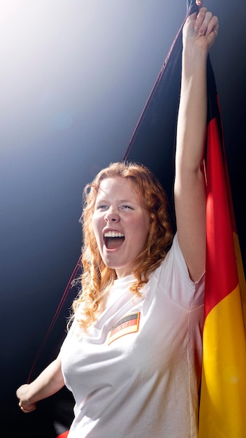 Foto grátis mulher segurando a bandeira alemã na frente