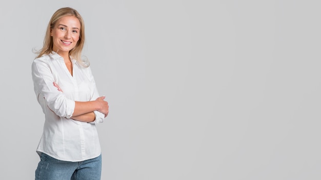 Mulher sorridente posando com os braços cruzados e copie o espaço