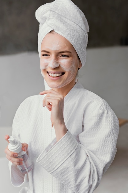 Foto grátis mulher sorridente usando um creme facial branco