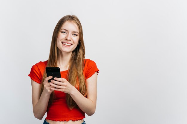 Mulher sorridente, verificando o telefone com espaço de cópia