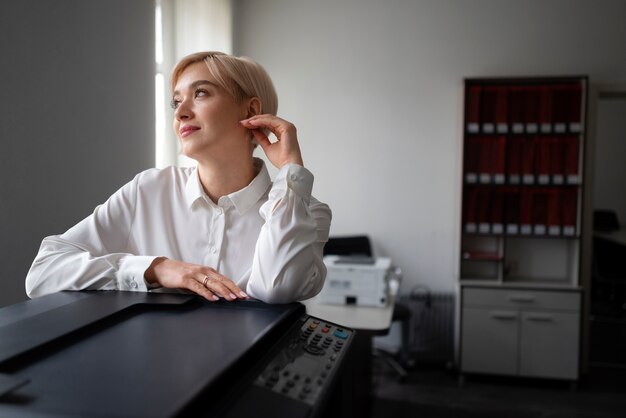 Mulher usando impressora enquanto trabalhava no escritório