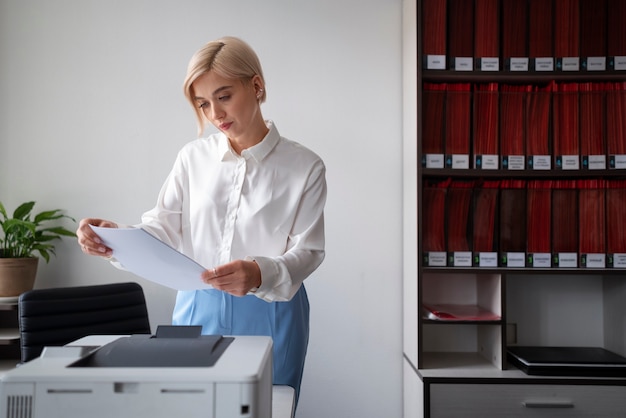 Mulher usando impressora enquanto trabalhava no escritório