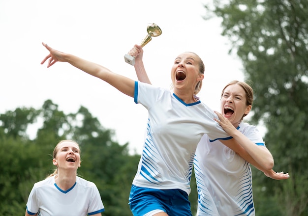 Foto grátis mulheres entusiasmadas com a copa dos vencedores