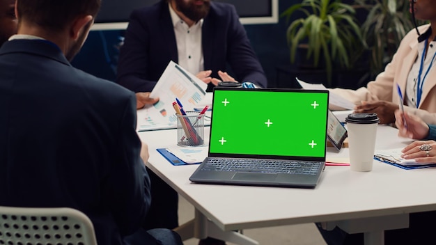 Foto grátis parceiros de negócios participando de uma reunião ao lado de um laptop de tela verde