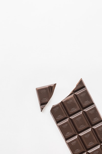 Foto grátis pedaço quebrado de barra de chocolate no fundo branco