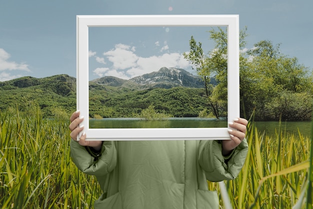 Pessoa segurando quadro com conceito de paisagem de natureza aberta