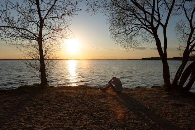 Foto grátis pessoa triste e contemplativa perto do lago