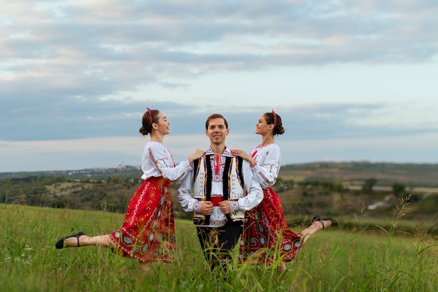 Foto grátis pessoas sorridentes de tiro completo vestindo roupas tradicionais