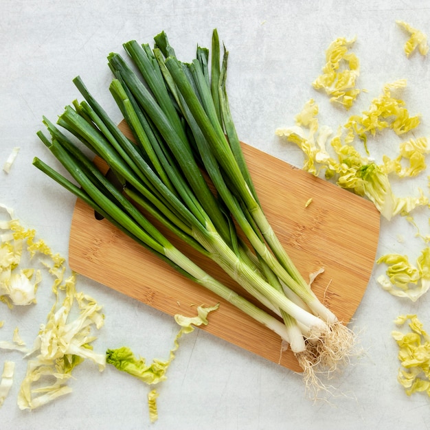 Foto grátis placa de madeira com cebola verde