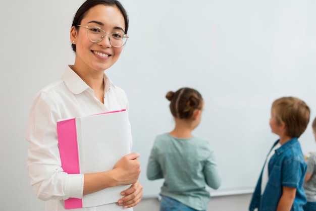 Foto grátis professor sorridente posando ao lado dos alunos