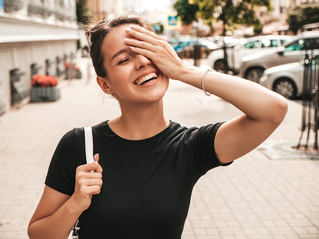 Foto grátis retrato da bela modelo sorridente, vestido com roupas de verão. menina na moda posando na rua. mulher engraçada e positiva se divertindo